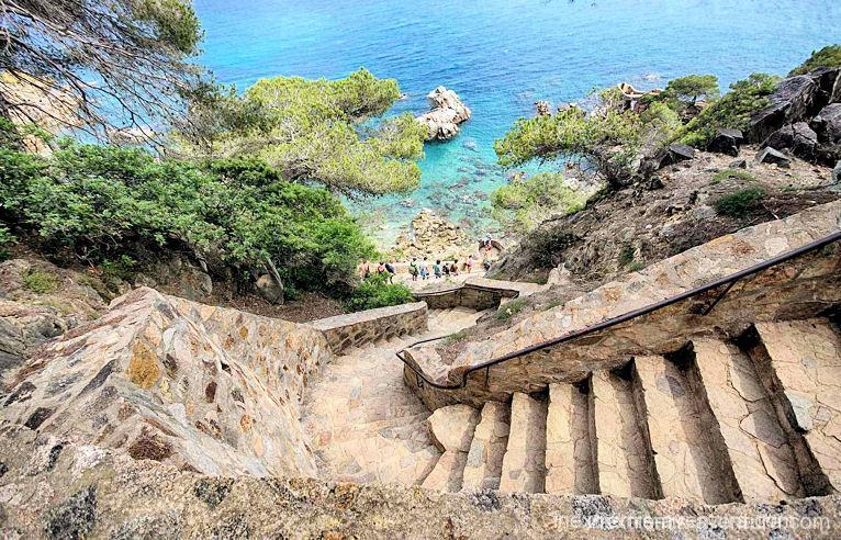 Vue en hauteur sur les escaliers d'un sentier côtier avec ses randonneurs lors d'une visite Catalogne