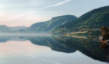 Paysage brumeux de Norvège avec une étendue d'eau et des montagnes