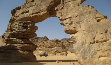 Randonnée guidée d'un groupe de touristes dans une voiture 4x4 entre les rochers dans le désert en Algérie.
