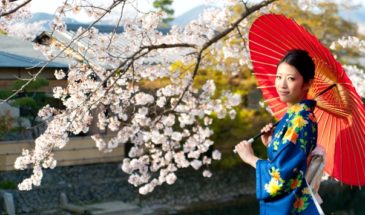 Femme japonaise qui tient un parapluie rouge