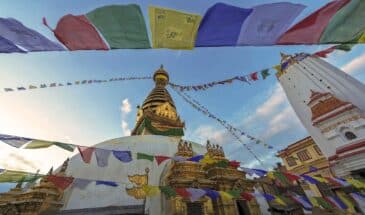Karhmandu temple Népal : il y a un magnifique temple de couleur blanche et or, qui est orné de drapeaux.