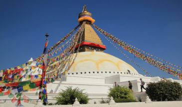 Monument religieux Népal : il y a un magnifique temple avec un sommet en or, qui est décoré de drapeaux.