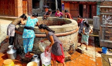Puits village Népal : il y a un puits avec de nombreuses femmes autour, certaines puisent de l'eau.