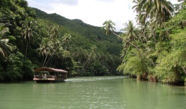 Rivière et forêt Bohol : il y a un bateau qui navigue sur la rivière, au milieu de la forêt et des montagnes.