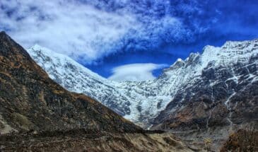 Voyage montagne Népal : il y a des vallées, et au loin des montagnes recouvertes de neige.