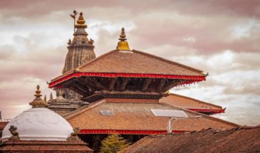 Annapurna trekking : il y a un grand temple de couleur rouge avec des panneaux solaires sur le toit.