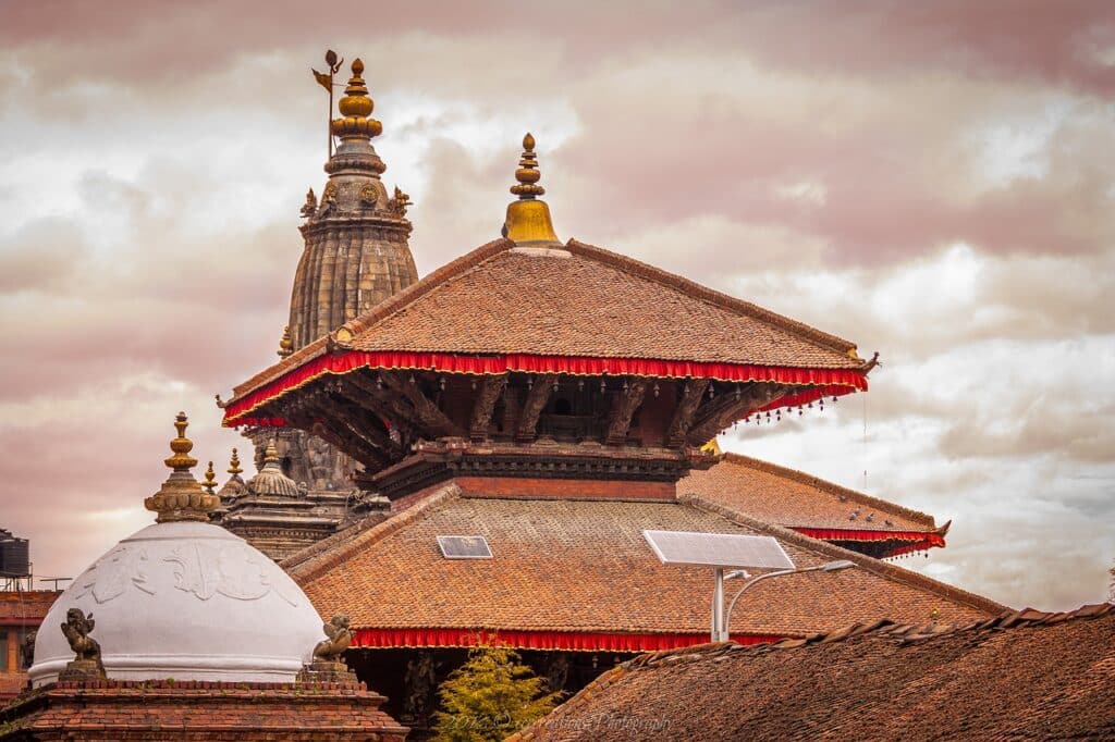 Grand tour Manaslu : il y a un grand temple de couleur rouge, avec des panneaux solaires sur le toit.