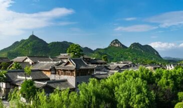 Guizhou promenade pleine air : sur les montagnes de Guizhou, avec une forêt dense, et des petites maisons.