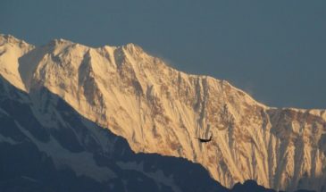 Mohare Danda en trek : il y a un hélicoptère qui vole devant les chaînes de montagne de l'Himalaya.