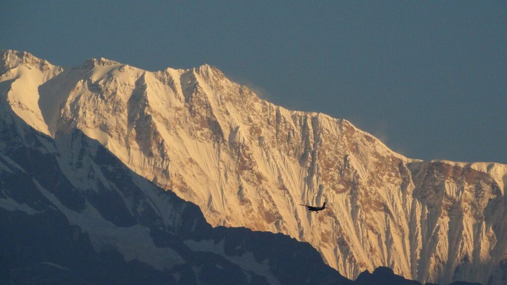 Mohare Danda en trek : il y a un hélicoptère qui vole devant les chaînes de montagne de l'Himalaya.