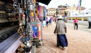 Randonnée Népal dans la ville. Il y a des habitants et des stands avec des objets de souvenir.