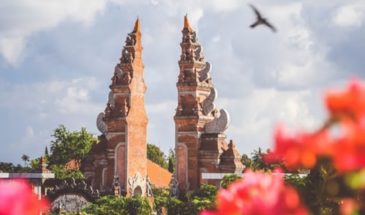 Temple Indonésie : un temple indonésien, en forme de deux tours orangées ainsi que des fleurs.