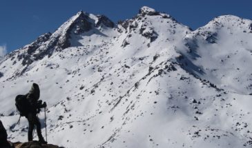 Terre du Népal : il y a un randonneur qui grimpe les montagnes recouvertes de neige.