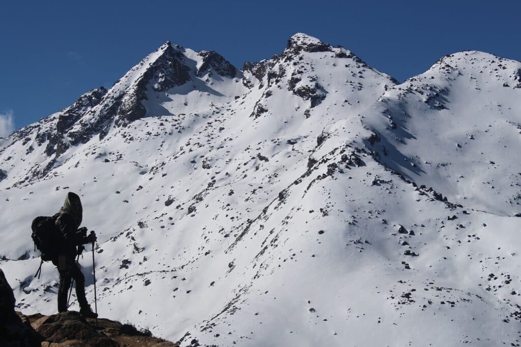 Terre du Népal : il y a un randonneur qui grimpe les montagnes recouvertes de neige.