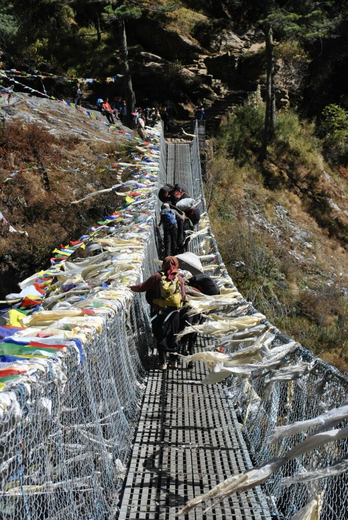 Tour de Manaslu, il y a un pont traversé par des habitants où sont accrochés des drapeaux de prières.