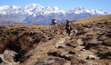 Trekking Langtang : deux hommes se baladent sur les sentiers de roche. Derrière eux, on aperçoit les montagnes.