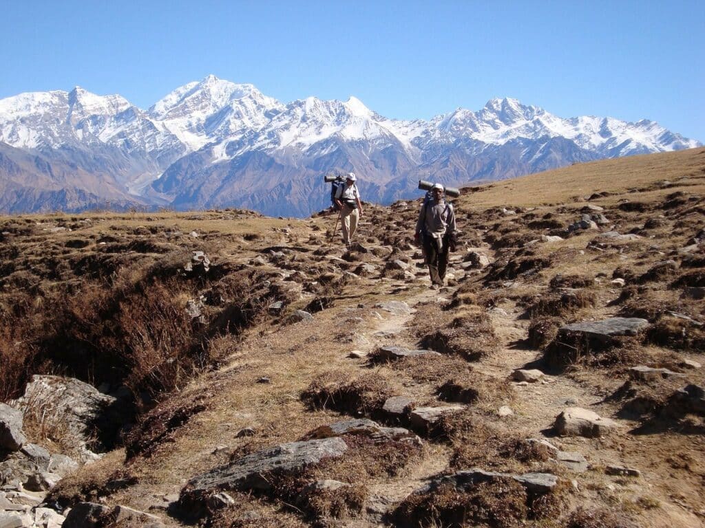 Trekking Langtang : deux hommes se baladent sur les sentiers de roche. Derrière eux, on aperçoit les montagnes.
