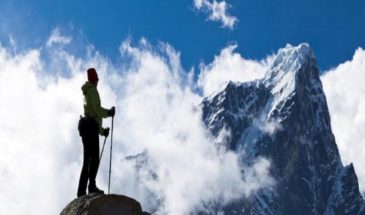 Voyage découverte Népal : il y a un randonneur sur le sommet d'un rocher, il regarde les hautes montagnes.