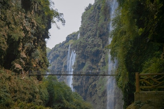 Voyage Guizhou : des cascades d'eaux, avec un pont reliant les deux montagnes.