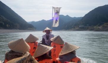 un bateau sur un lac, portant des personnes habillées traditionnellement.