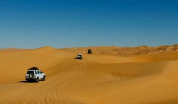 Plusieurs voitures 4x4 qui se suivent dans le désert Tassili du Hoggar dans le Nord de l'Algérie