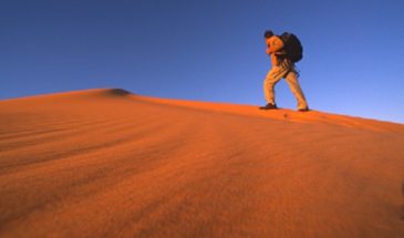 Groupe de touristes grimpant les collines de sable dans le désert de l'Erg Chech