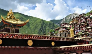 Trek Tibet Oriental : des maisons de couleur rouge, typique chinoisent oriental sur des montagnes.