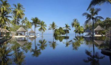Voyage Bali : un lieu de bien-être, des tentes, avec de l'eau et des palmiers sous un ciel bleu.