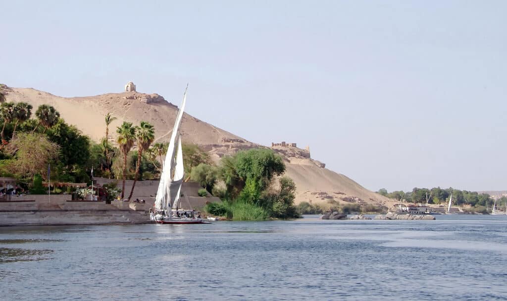 Nil en Feloupe, Balade en bateau sur le lac Nasser bordant un désert et les arbres.