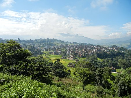 Famille randonnée : à la découverte du Népal, il y a une ville au milieu des arbres et de la végétation.
