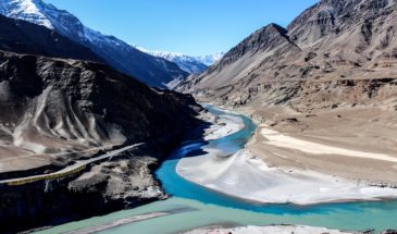 Randonnée en Inde : la vallée de l'indus, au milieu une rivière bleue ainsi qu'une route montagneuse.