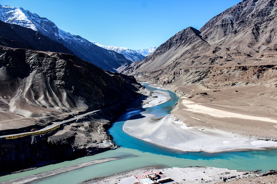 Randonnée en Inde : la vallée de l'indus, au milieu une rivière bleue ainsi qu'une route montagneuse.