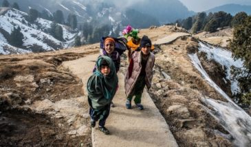 Randonnée Himalaya : des enfants le long d'une route, froidement habillés, au sommet de la montagne enneigée.