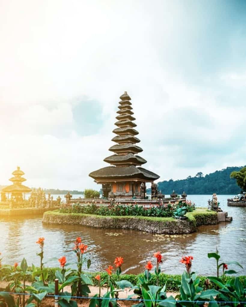 Séjour Bali : un temple en forme de tour au milieu d'un lac ainsi que des montagnes entourant le lac.