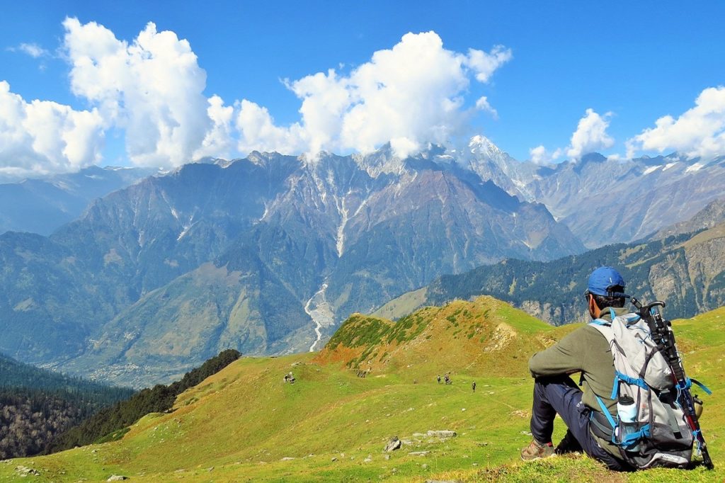 Séjour Himalaya : des randonneurs sur une montagne en Inde ainsi qu'un homme assis, observant le paysage.