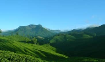 Trek Kerala : Coorg Bangalore est un paysage montagneux et de verdure, avec un ciel bleu.