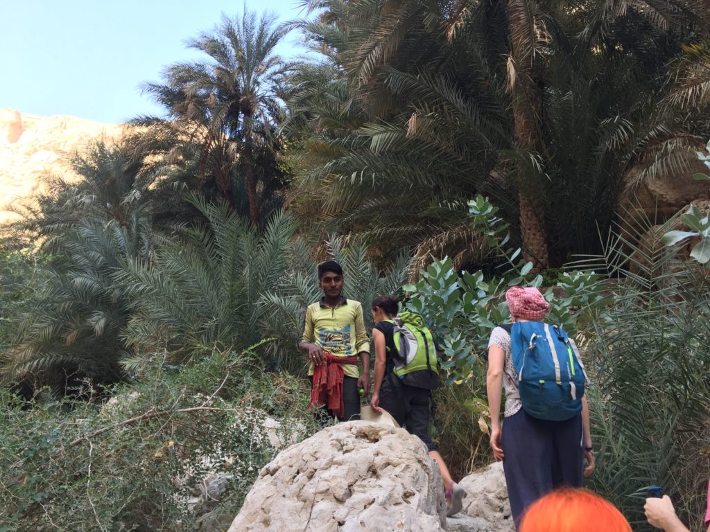 Excursions Oman, des randonneurs et un habitant sur Jebel Akhdar à Oman, au milieu de palmiers.