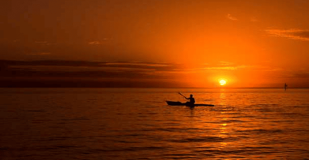 Kayak corse du sud, une femme en canoë au milieu de la mer avec le coucher du soleil