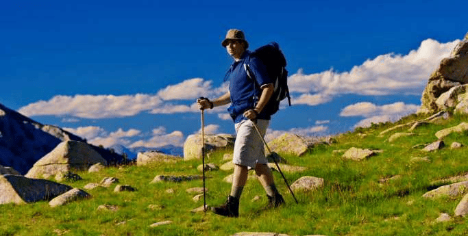 Un homme sur le chemin pour atteindre le sommet de la montagne trek en Roumanie
