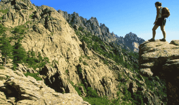 Un randonneur sur le sommet une montagne admirant d'autres montagne,accompagnateur randonnée Corse