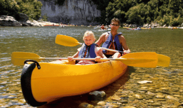 Un homme et une petite fille sur un canoë dans un lac, activités Cévennes
