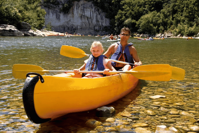 Un homme et une petite fille sur un canoë dans un lac, activités Cévennes
