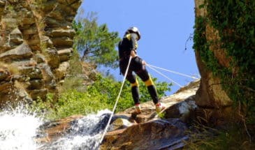 Kayak Oman : un femme faisant du canyoning en descendant une cascade