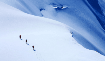 Groupe qui marche sur une piste montagneuse plein de neige, randonnée Chamonix Zermatt