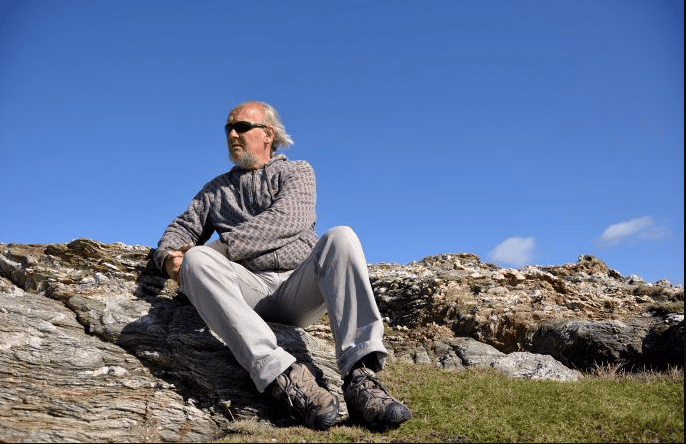 Homme assis sur une roche admirant la splendeur du paysage, tour de Belle-île