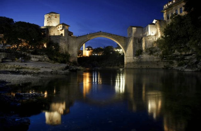 Voyage Bosnie Herzégovine, vue de splendides sur un lacs au dessus un pont liane un château a l'autre côté du château